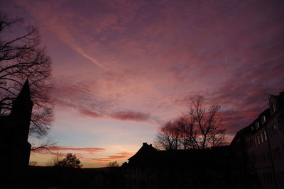 Low angle view of silhouette buildings against sky at sunset