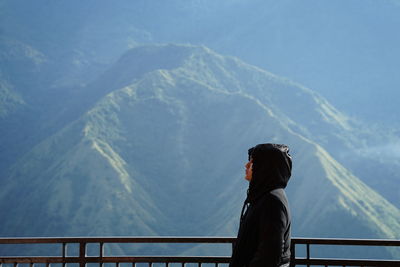 Rear view of woman standing against mountain