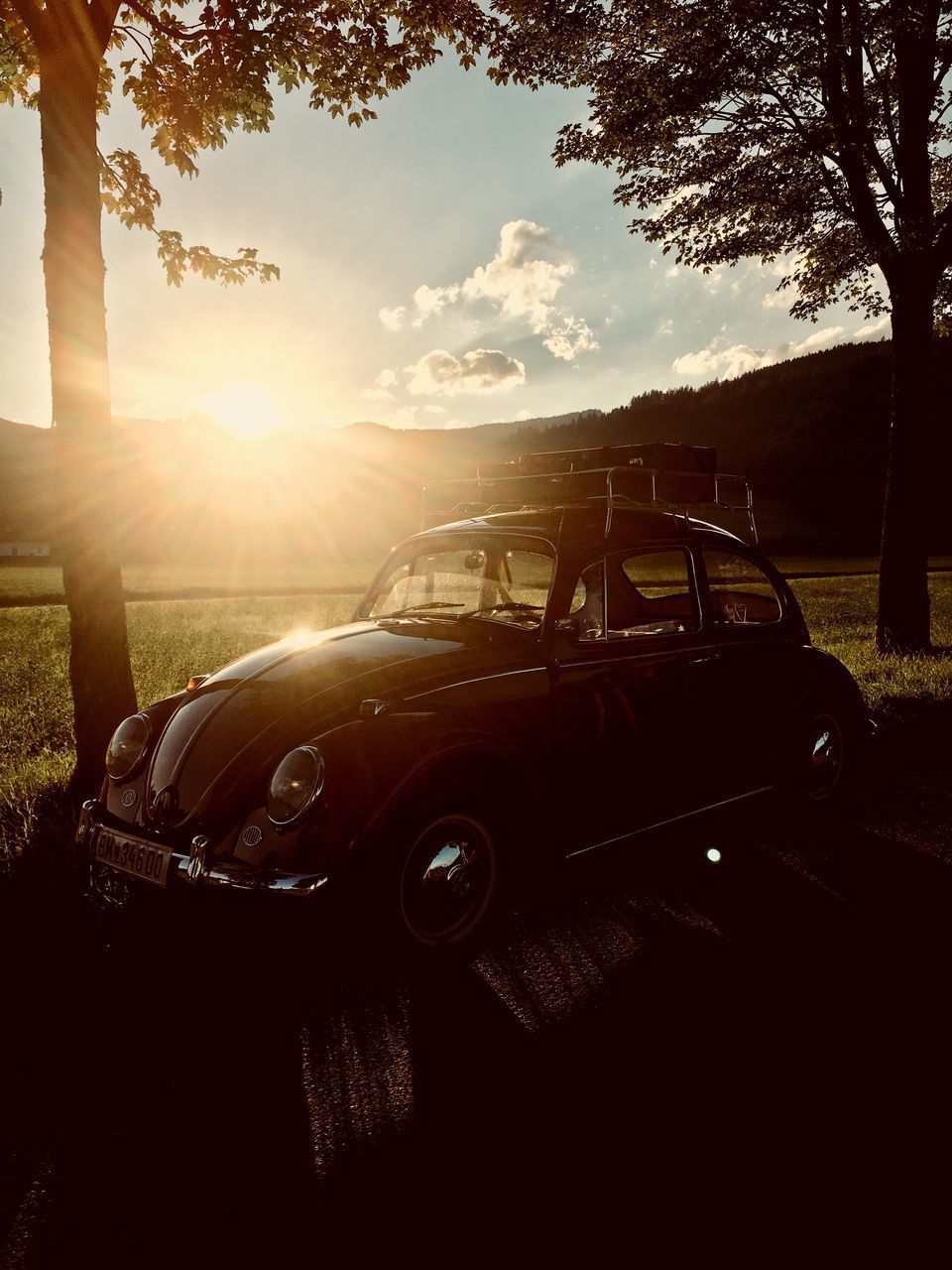 CAR ON ROAD AGAINST SKY AT SUNSET