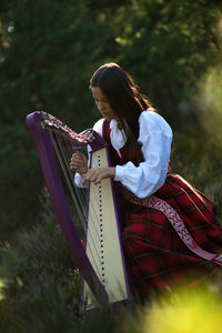 Woman playing harp outdoors