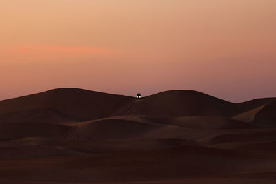 Scenic view of desert against sky during sunset