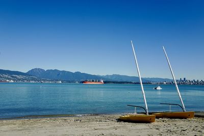 Sailboats on sea against clear blue sky