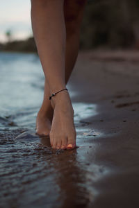 Low section of woman standing on beach