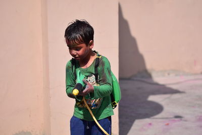 Boy playing with squirt gun during holi