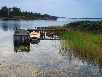 Boat moored in lake against sky