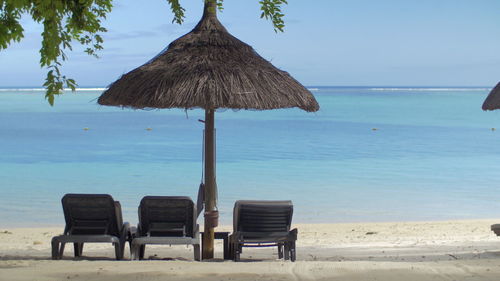 Chairs on beach against sky