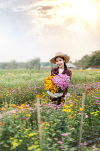 Portrait of a beautiful young woman standing on field