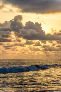 Scenic view of sea against cloudy sky at sunset