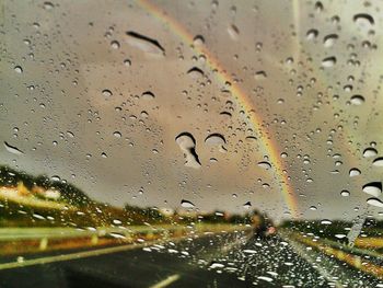 Road seen through wet glass window