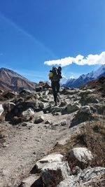 Man standing on rock against sky