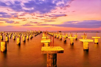 Pier over sea against sky during sunset