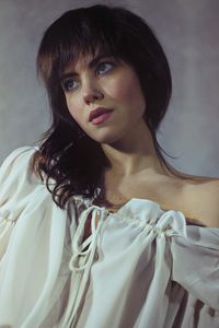 Low angle view of thoughtful young woman standing against wall