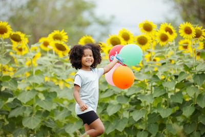 Happy girl with balloons in plants