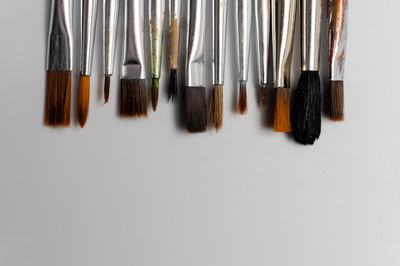 High angle view of make-up brushes against white background