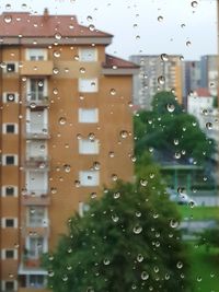 Close-up of wet window in city during rainy season