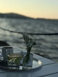 Close-up of drink on table against sky during sunset