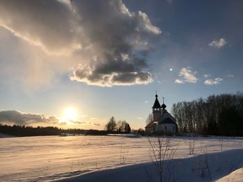 Built structure on snow covered landscape against sky