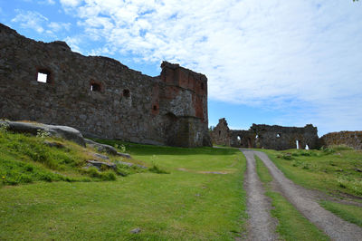 Old building by road against sky