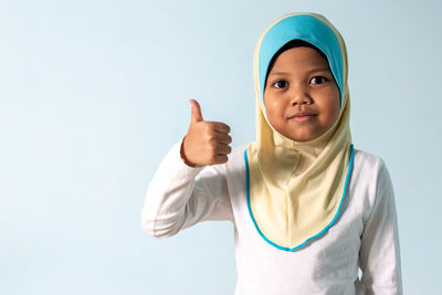 Portrait of smiling boy standing against white background