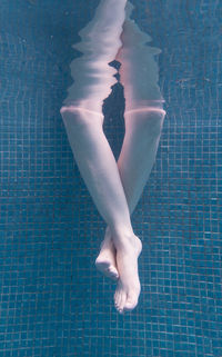 Low section of woman swimming in pool