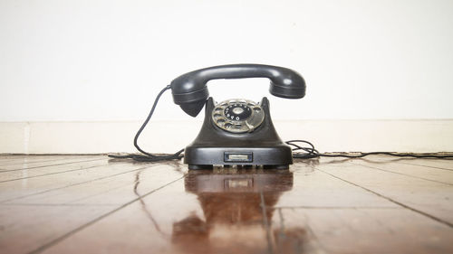 Close-up of telephone booth on table against wall