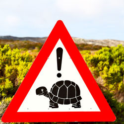 Close-up of road sign against sky