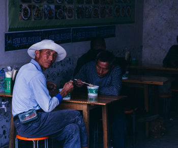 Young man sitting on table at home