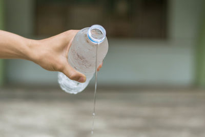 Close-up of hand pouring water in bottle