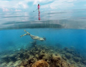 Young women have a fun in ocean water, underwater view