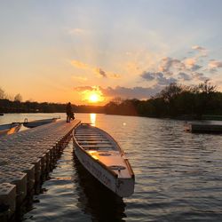 Pier over lake against sky during sunset