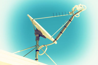 Low angle view of telephone pole against clear blue sky