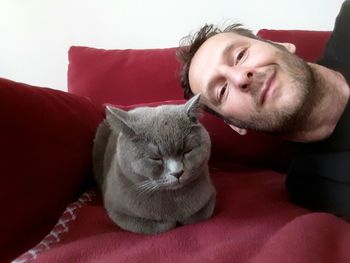 Portrait of man with british shorthair cat on sofa at home