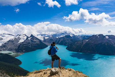 Rear view of woman standing on landscape with mountain range in background