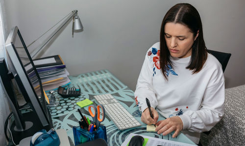 High angle view of woman sitting on bed