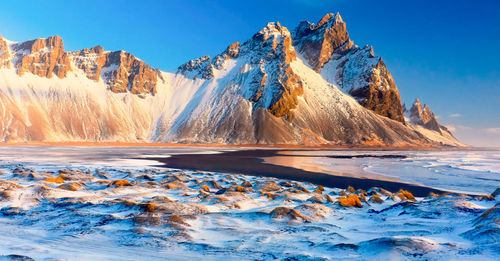 Scenic view of snowcapped mountains against blue sky,vestrahorn beach