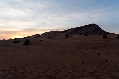 Scenic view of desert against sky during sunset