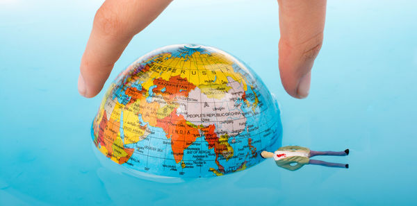 Cropped hand holding globe in swimming pool