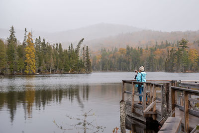 Man standing on lake against trees