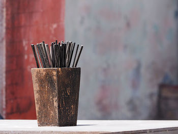 Close-up of metallic structure on table against wall