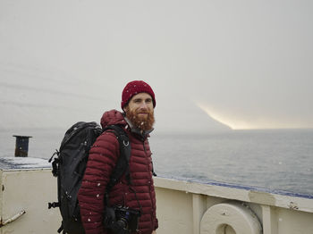 Bearded man looking at camera, while on ferry in the faroe islands