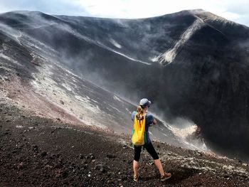 Rear view of woman standing on mountain