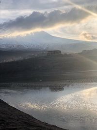 Scenic view of lake by mountains against sky