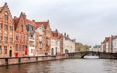 Bridge over river against buildings in city