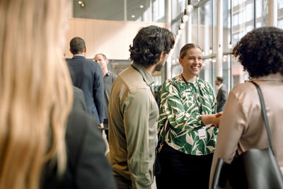 Group of male and female business delegates interacting with each other during event at convention center