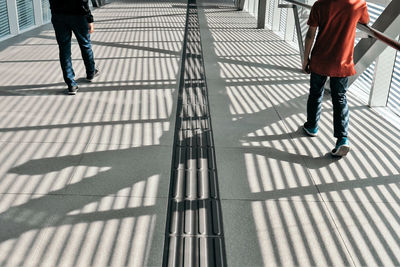 Low section of men walking on footbridge in city