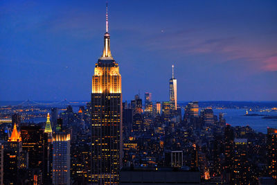 Illuminated buildings in city against sky