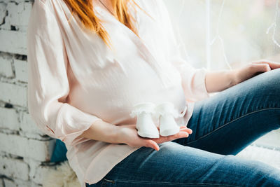 Low section of woman sitting on bed