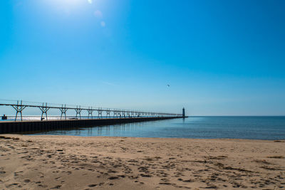 Scenic view of beach against clear blue sky