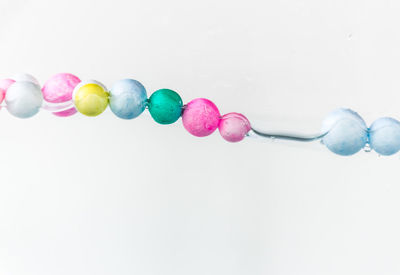 Close-up of multi colored candies against white background