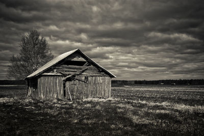 Abandoned house on field against sky